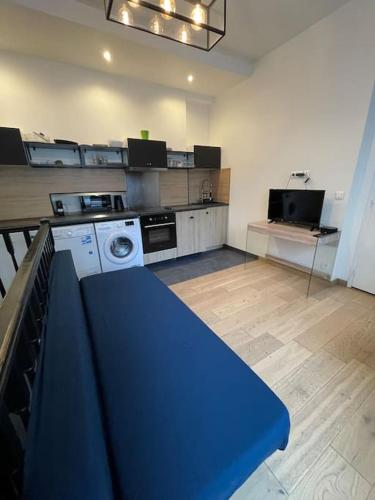un banc bleu dans une pièce avec cuisine dans l'établissement confortable appartement 3 pièces Flatters, à Paris