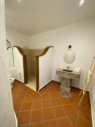 a bathroom with a toilet and a tiled floor at Casa Laberinto in San Miguel de Allende