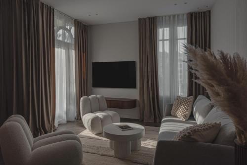 sala de estar con muebles blancos y TV de pantalla plana en Modern 1 Bedroom Apartment next to Monte Carlo, en Beausoleil