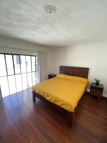 a bedroom with a bed with a yellow bedspread at Casa Laberinto in San Miguel de Allende