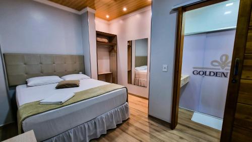 - une chambre avec un lit et une porte coulissante en verre dans l'établissement Golden View Hotel, à Capitão Leônidas Marques