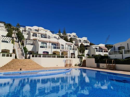 a swimming pool in front of some white buildings at Appartement vue sur mer in Agadir