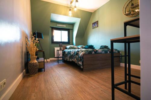 1 dormitorio con 1 cama en una habitación con paredes verdes en Green cosy, en Louviers