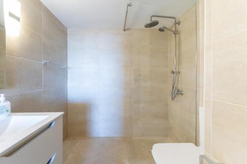 y baño con ducha, aseo y lavamanos. en Beachfront Puerto Cabopino, en Marbella