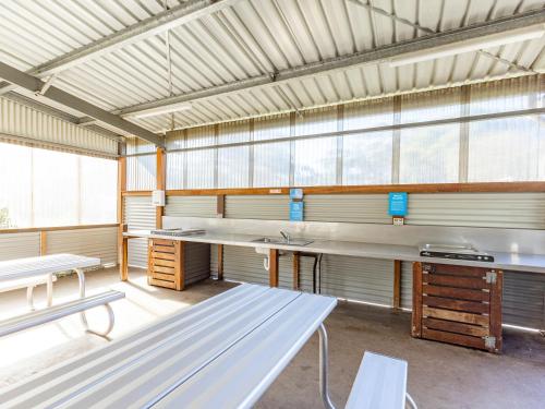 a large room with tables and benches in a building at NRMA Halls Gap Holiday Park in Halls Gap