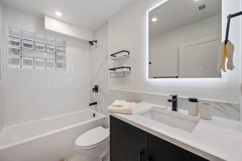 a white bathroom with a sink and a toilet at Logan Square Luxury Villa, 3 Beds, 3 Baths in Chicago