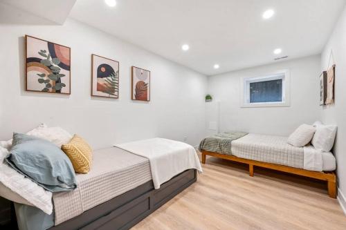duas camas num quarto branco com pinturas na parede em Logan Square Luxury Villa, 3 Beds, 3 Baths em Chicago