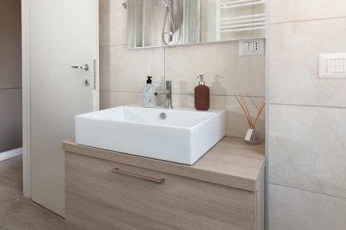 y baño con lavabo blanco y espejo. en Van Gogh Exclusive Apartment, en Milán