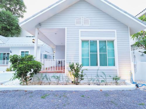 a white house with a porch and a window at Baan Casita With Private Seaside Cottage in Hua Hin