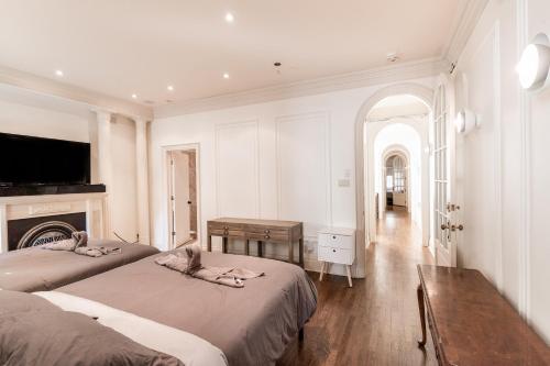 um quarto branco com 2 camas e uma lareira em Superb city center Penthouse on two floors-C em Montreal