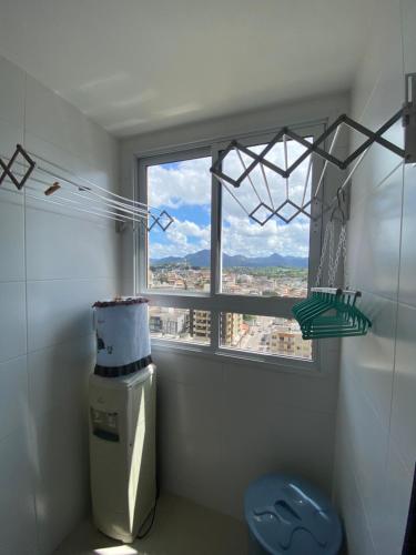 a bathroom with a toilet and a window with a view at Apto NOVO BEIRA MAR Praia do Morro vista mar e montanha com 120m 3 qtos Ed Elegance limitado a 8 hóspedes independente da idade in Guarapari