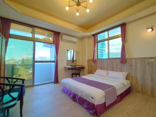 a bedroom with a bed and a large window at 陶陶居商旅 Tautauchu Hotel in Hualien City