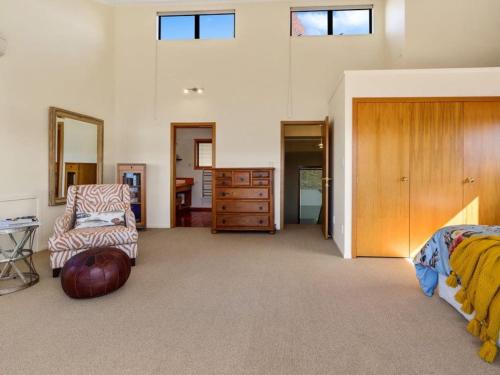 a bedroom with a bed and a chair and a dresser at The Terrace Lake Tarawera in Lake Tarawera
