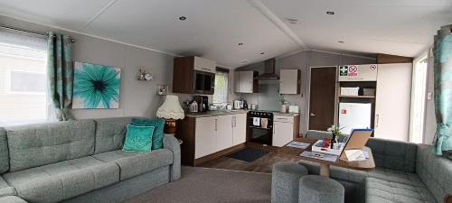 Haven Rockley Park, Lytchett Bay View, Private Holiday Home - Caravan في Lytchett Minster: غرفة معيشة مع أريكة ومطبخ
