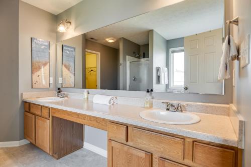 a bathroom with two sinks and a large mirror at Indianapolis Home with Patio and Community Pool! in Indianapolis