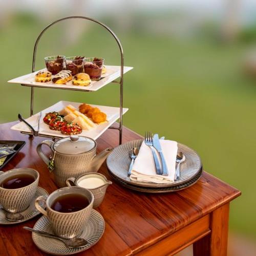 a table with a tray of pastries and cups of coffee at Outrigger Fiji Beach Resort in Korotogo