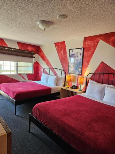 a hotel room with two beds and red walls at Huntington Surf Inn in Huntington Beach