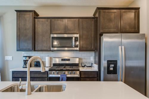 a kitchen with wooden cabinets and a stainless steel refrigerator at Cozy Cartersburg Home about 14 Mi to Indianapolis in Cartersburg