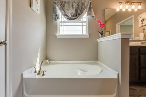 a white bath tub in a bathroom with a window at Cozy Cartersburg Home about 14 Mi to Indianapolis in Cartersburg