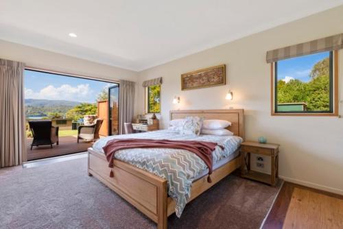 Lake TaraweraにあるRiverstone Lake Taraweraのベッドと大きな窓のある寝室