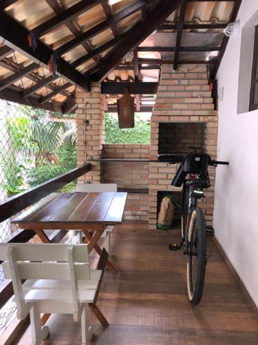 a picnic table and a bike in a room with a fireplace at Flat Maresias in Maresias