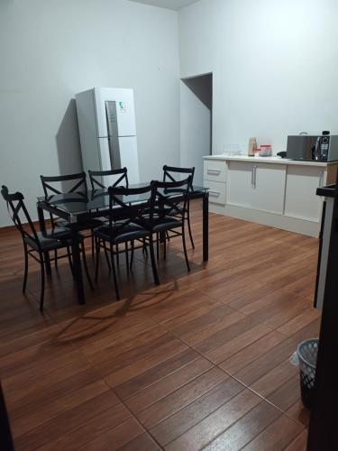 a dining room with a table and chairs in a kitchen at Casa Dona de casa. in Ribeirão Preto