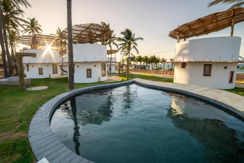 una piscina en el patio de una casa con palmeras en VentoVinte Beach Club, en Flecheiras