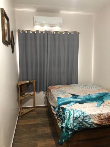 1 dormitorio con cama y cortina gris en Flat Maresias en Maresias