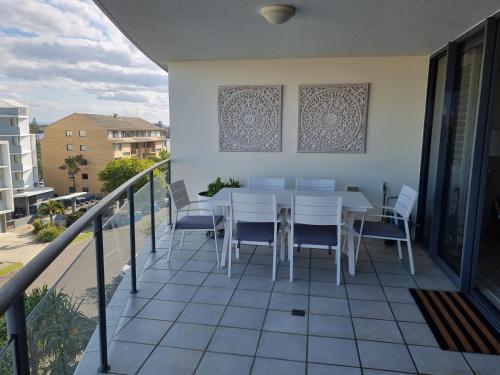 a patio with a table and chairs on a balcony at The Waterford Prestige Apartments in Caloundra