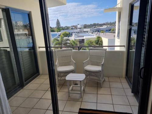 a balcony with chairs and a view of a city at The Waterford Prestige Apartments in Caloundra