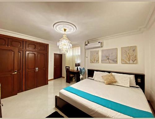 ein Schlafzimmer mit einem großen Bett und einem Kronleuchter in der Unterkunft Habitacion Master a cinco minutos del aeropuerto in Guayaquil