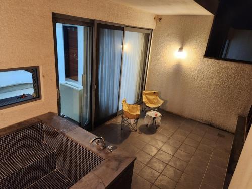 a bathroom with a tub and a chair and a window at Jeju Breeze in Seogwipo
