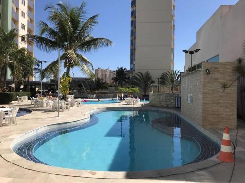 a large swimming pool with a palm tree and buildings at Thermas do Bandeirante in Caldas Novas