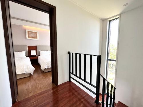 a hallway leading to a bedroom with a mirror at Jeju Breeze in Seogwipo