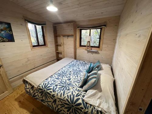ein kleines Schlafzimmer mit einem Bett in einer Hütte in der Unterkunft River Lodge in Pucón