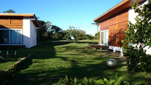 a yard next to a house with a building at Casa da Ilha do Mel - Pousada de Charme in Ilha do Mel