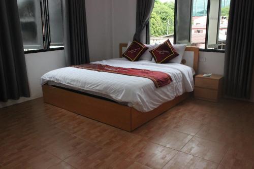 1 dormitorio con 1 cama con sábanas y almohadas blancas en Vientiane Garden Hostel en Vientián