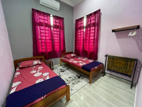 um quarto com 2 camas, cortinas cor-de-rosa e uma lareira em Nice bungalow with view of paddy fields em Tumpat