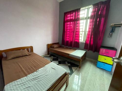a bedroom with a bed and a window with pink curtains at Nice bungalow with view of paddy fields in Tumpat