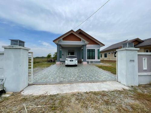 una casa con una entrada delante de ella en Nice bungalow with view of paddy fields en Tumpat