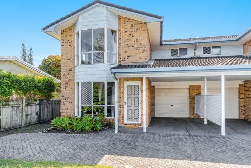 a brick house with a white door and a driveway at Clippers 1 - Pet Friendly Holiday Home - Holiday Yamba in Yamba