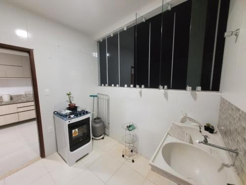 a white bathroom with a sink and a stove at Guaibim in Guaibim