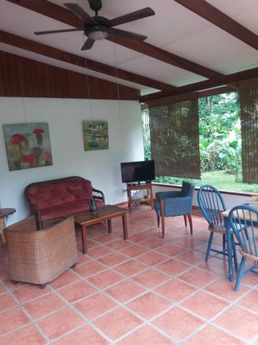 sala de estar con sofá, mesa y sillas en Los Delfines Lodge, en Puerto Viejo