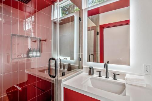 uma casa de banho vermelha com um lavatório e um espelho em Strawberry Container @ EADO Juice Box em Houston