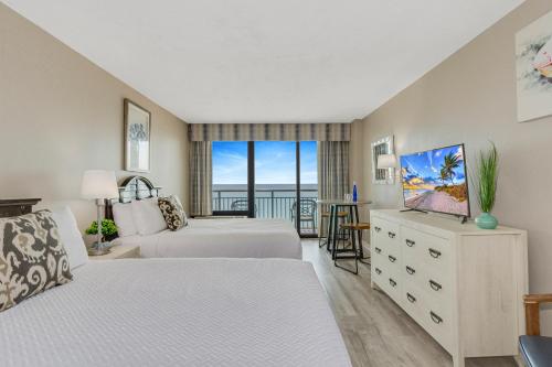 a bedroom with two beds and a balcony at Oceanview Studio Escape With Beach Steps Away! 1828 in Myrtle Beach