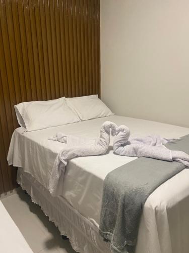 a bed with white sheets and towels on it at Origem in Mamanguape