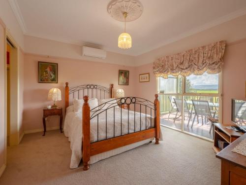1 dormitorio con 1 cama y balcón en Woodview Cottage Farm stay, en Port Welshpool