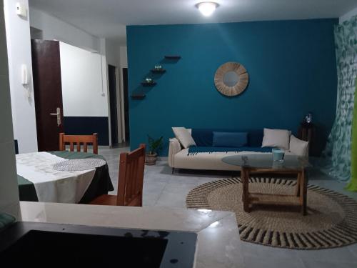 a living room with a couch and a blue wall at Ado Mishkan in Cayenne