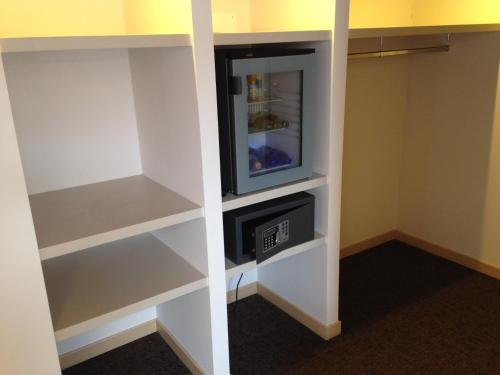 a walk in closet with a tv and shelves at Hotel Don Abbondio in Lecco