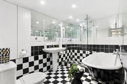 baño con suelo a cuadros en blanco y negro en Stylish Darlinghurst Townhouse l 3 Bedrooms, en Sídney